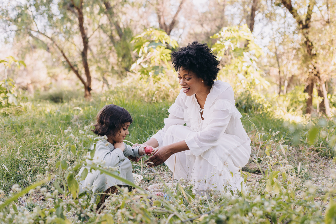 Mother and Daughter Hunting for Easter Eggs Outdoors